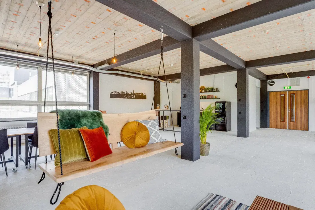 De schommelbank in de Loft met kussens, bij de grote ramen