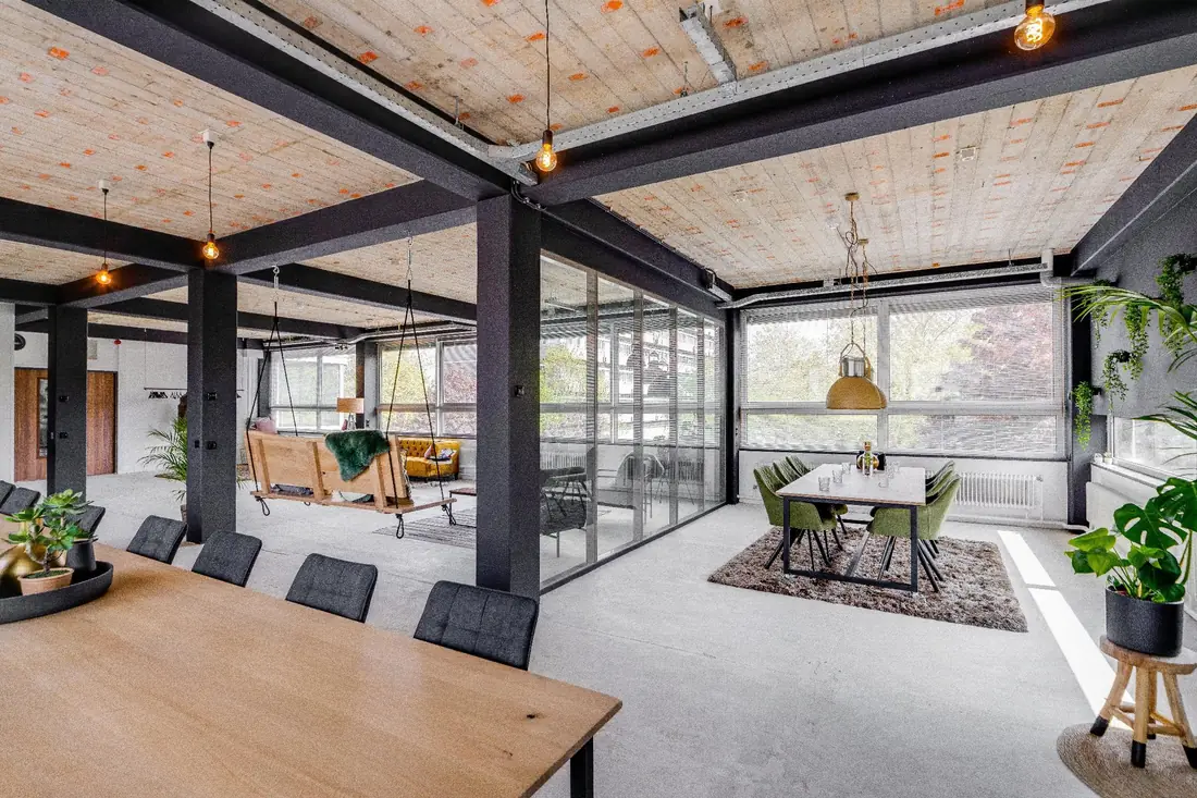 Overzicht van de Loft met tafels, lounge en de break-out ruimte achter glas