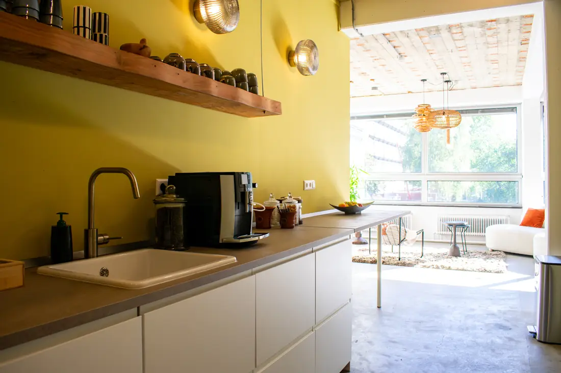 Aanrecht en koffiemachine in de Studio, met zicht op de lounge